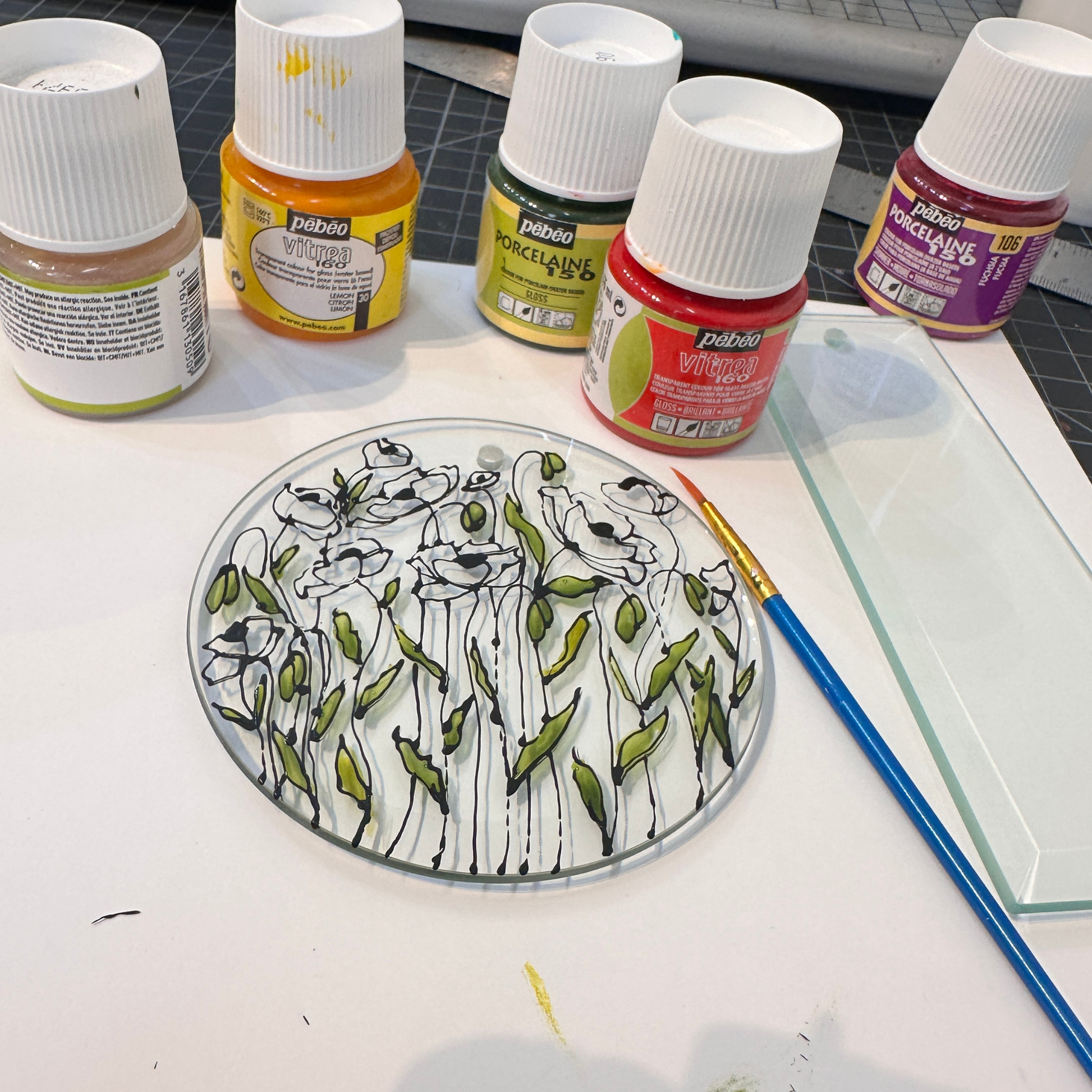 Artistic depiction of flowers on a round glass plate made during an art workshop with Sarita Kamat at Artem Pop Up Gallery