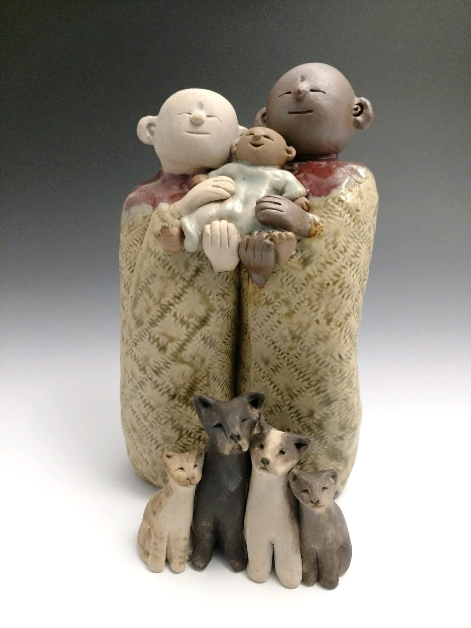 Ceramic statue of parents, baby, and their pets made by Anne Maraviglia