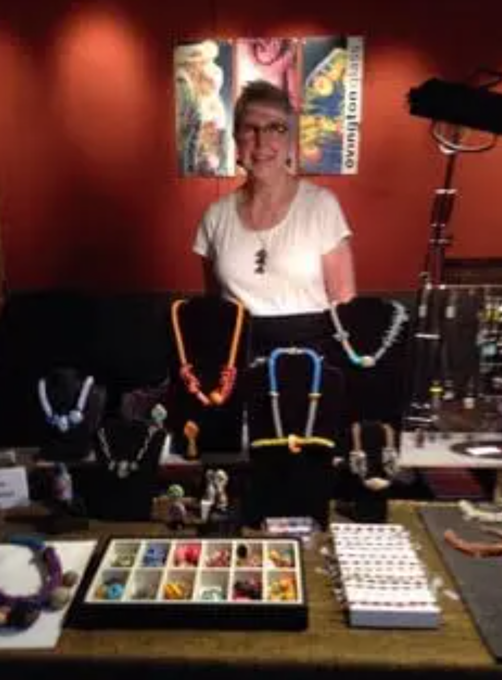 Karen Ovington of Karen Ovington Glass Studio standing behind her artwork