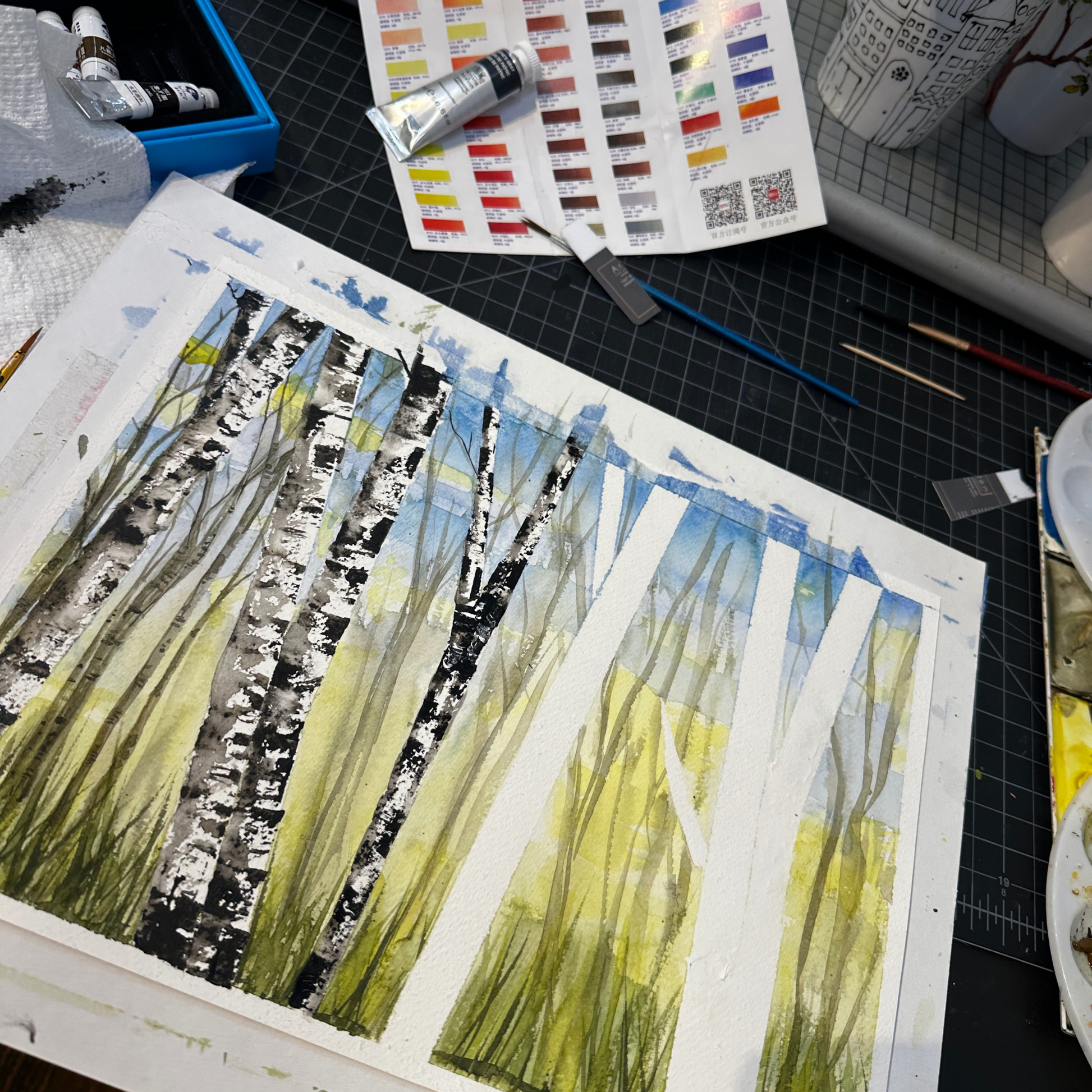 Artistic depiction of trees on a canvas with painting supplies around, made by Sarita Kamat of Artem Pop Up Gallery