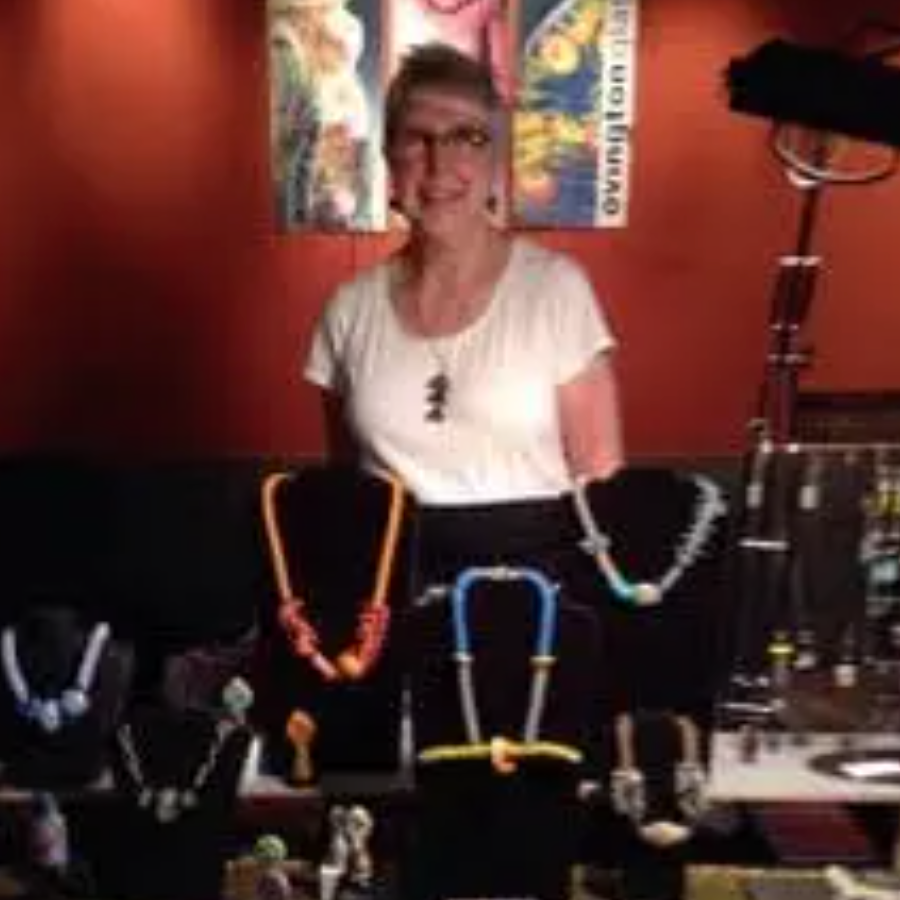 Karen Ovington of Karen Ovington Glass Studio standing behind her glass artwork